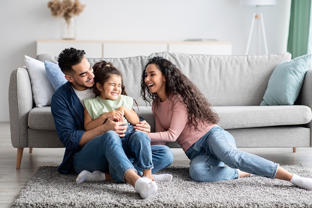 mom and dad playing with young son on the floor